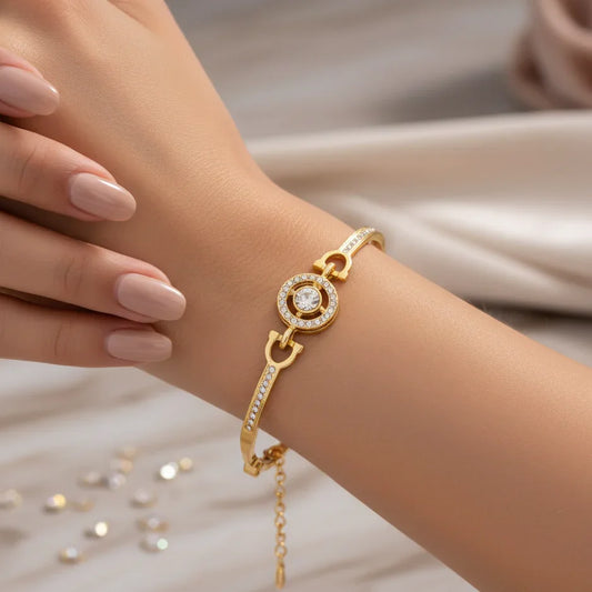 Gold bracelet with a diamond on a wrist against a soft background, Aurora Jewelry brand visible.