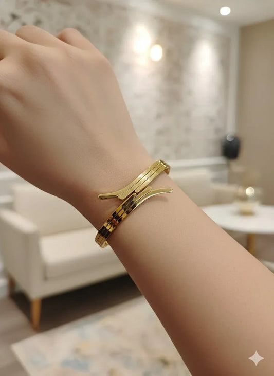 Gold bracelet on a wrist with a blurred indoor background